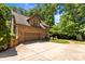 Brick house exterior featuring an attached garage with a large driveway and lush green trees at 6565 Robin Hollow Dr, Mint Hill, NC 28227