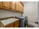 Functional laundry room featuring washer, dryer, granite counters, and custom wood cabinetry at 6565 Robin Hollow Dr, Mint Hill, NC 28227