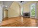 Spacious living room with a stone fireplace, vaulted ceilings, and large arched windows at 6565 Robin Hollow Dr, Mint Hill, NC 28227