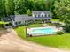 Stunning aerial view of a home with a pool, lush greenery, and a long driveway at 675 Ormand Rd, York, SC 29745