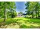 Large backyard with mature trees and manicured lawn, perfect for outdoor activities at 675 Ormand Rd, York, SC 29745