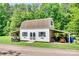 Rustic barn with covered storage, surrounded by a lush green lawn and mature trees at 675 Ormand Rd, York, SC 29745