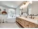 Luxurious bathroom featuring dual sinks, a soaking tub, and stylish fixtures and an arch window at 675 Ormand Rd, York, SC 29745