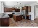 Open kitchen with a center island, stainless steel appliances, and dark wood cabinets at 7129 Dove Field Ln, Fort Mill, SC 29707
