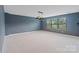 Spacious living room with neutral carpet, a modern light fixture, and large windows at 7129 Dove Field Ln, Fort Mill, SC 29707
