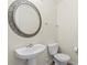 Powder room featuring an ornate oval mirror above a pedestal sink and a toilet at 7136 Bullock Dr, Charlotte, NC 28214