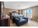 Comfortable bedroom featuring a well-made bed, a loveseat, and dresser, illuminated by natural light at 7136 Bullock Dr, Charlotte, NC 28214