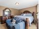 Well-lit bedroom with a dresser, queen-sized bed, and a cozy loveseat near a window at 7136 Bullock Dr, Charlotte, NC 28214