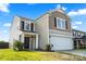 Two-story home with brown accents, a two-car garage, and landscaped front yard at 7136 Bullock Dr, Charlotte, NC 28214