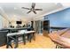 Finished basement featuring bar, stools, TV, ceiling fan, laminate flooring and slider doors to the outside at 7218 Cascading Pines Dr, Fort Mill, SC 29708