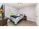 Clean bedroom with wood-look floors, featuring a comfortable bed and a well-lit window at 7218 Cascading Pines Dr, Fort Mill, SC 29708