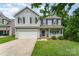Charming two-story home featuring a welcoming front porch and a well-maintained lawn with a two car garage at 7218 Cascading Pines Dr, Fort Mill, SC 29708