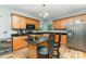 A well-lit kitchen with wooden cabinets, granite countertops, stainless steel appliances, and an island with seating at 7218 Cascading Pines Dr, Fort Mill, SC 29708