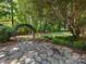 Lush backyard featuring a stone patio, decorative archway, and green landscaping at 911 Munday Ct, Charlotte, NC 28270