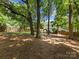 A serene backyard with mature trees offers privacy with a wooden fence at 911 Munday Ct, Charlotte, NC 28270