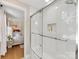 Bathroom view of glass enclosed tiled shower and adjacent main bedroom at 911 Munday Ct, Charlotte, NC 28270