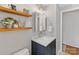 Well-lit bathroom with floating shelves, a framed mirror, and a vanity with storage at 911 Munday Ct, Charlotte, NC 28270