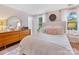 Bright bedroom boasts natural light, a round mirror, and hardwood floors at 911 Munday Ct, Charlotte, NC 28270