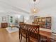 Bright dining room with wood floors features a wood table next to the open concept living room at 911 Munday Ct, Charlotte, NC 28270