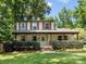 Inviting two-story home with a classic design, featuring a covered front porch, manicured shrubs, and a lush lawn at 911 Munday Ct, Charlotte, NC 28270