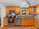 Kitchen with stainless appliances, granite countertops, wood cabinets, and a window with a view of the backyard at 911 Munday Ct, Charlotte, NC 28270