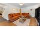Living room with hardwood floors, brown couch and a glass table at 911 Munday Ct, Charlotte, NC 28270
