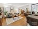 Bright and airy living room with modern decor, wood floors, a piano, and a cozy seating area at 911 Munday Ct, Charlotte, NC 28270