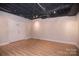 Finished basement space with exposed ceiling, recessed lighting, and double door access at 9117 Castle Garden Ln, Charlotte, NC 28215