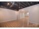 Finished basement area with an open ceiling concept and view into another space at 9117 Castle Garden Ln, Charlotte, NC 28215