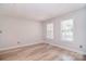 Neutral bedroom featuring hardwood floors, two windows providing natural light, and a spacious layout at 9117 Castle Garden Ln, Charlotte, NC 28215