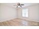 Bedroom featuring light-toned wood floors, ceiling fan, and natural light from one window at 9117 Castle Garden Ln, Charlotte, NC 28215