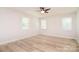 Bright bedroom features a ceiling fan, wood floors, and three windows for natural light at 9117 Castle Garden Ln, Charlotte, NC 28215