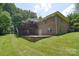 Exterior of home featuring brick, a large deck, and a spacious yard at 9117 Castle Garden Ln, Charlotte, NC 28215