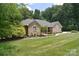 Lovely brick home featuring lush green lawn, mature trees and manicured landscaping around the foundation at 9117 Castle Garden Ln, Charlotte, NC 28215