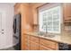 Kitchen sink and window with stainless steel appliances, granite counters, and wood cabinets at 9117 Castle Garden Ln, Charlotte, NC 28215