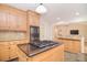 Kitchen featuring island with gas cooktop, granite countertops, and wooden cabinetry at 9117 Castle Garden Ln, Charlotte, NC 28215