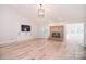 Inviting living room featuring hardwood floors, built-in cabinets, and a brick fireplace at 9117 Castle Garden Ln, Charlotte, NC 28215