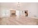 Open-concept living room with hardwood floors, brick fireplace, and seamless transition to the kitchen at 9117 Castle Garden Ln, Charlotte, NC 28215