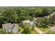 Aerial view of a house with a gray roof, long driveway and beautifully manicured lawn in a tree-filled community at 9121 Four Acre Ct, Charlotte, NC 28210