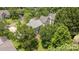 Aerial view of the home with lush greenery, a well-maintained lawn, and a brick patio at 9121 Four Acre Ct, Charlotte, NC 28210