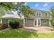 Back of house with patio and large backyard featuring lush green lawn and trees at 9121 Four Acre Ct, Charlotte, NC 28210