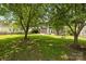 Expansive backyard featuring mature trees, green grass, swing set and patio of a two-story home at 9121 Four Acre Ct, Charlotte, NC 28210