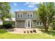 View of the backyard featuring a well-maintained lawn, a brick patio and a home with neutral siding and white windows at 9121 Four Acre Ct, Charlotte, NC 28210