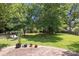 A spacious backyard with a swing and surrounded by lush trees at 9121 Four Acre Ct, Charlotte, NC 28210