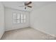 This bedroom features a ceiling fan, neutral carpet, and a window with plantation shutters at 9121 Four Acre Ct, Charlotte, NC 28210