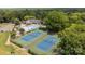 Aerial view of community amenities featuring a swimming pool and tennis courts surrounded by trees and landscaping at 9121 Four Acre Ct, Charlotte, NC 28210