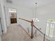 Upstairs hallway with wood railing and staircase, view of remodeled bathroom at 9121 Four Acre Ct, Charlotte, NC 28210