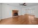 Bright living room boasts hardwood floors, a ceiling fan, and a charming fireplace at 9121 Four Acre Ct, Charlotte, NC 28210