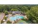 Aerial view of the community pool and clubhouse with tennis courts surrounded by lush greenery at 9121 Four Acre Ct, Charlotte, NC 28210