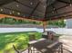 Inviting backyard with a covered patio, outdoor furniture, grill, and a well-manicured lawn at 9123 Magnolia Lily Ave, Charlotte, NC 28227